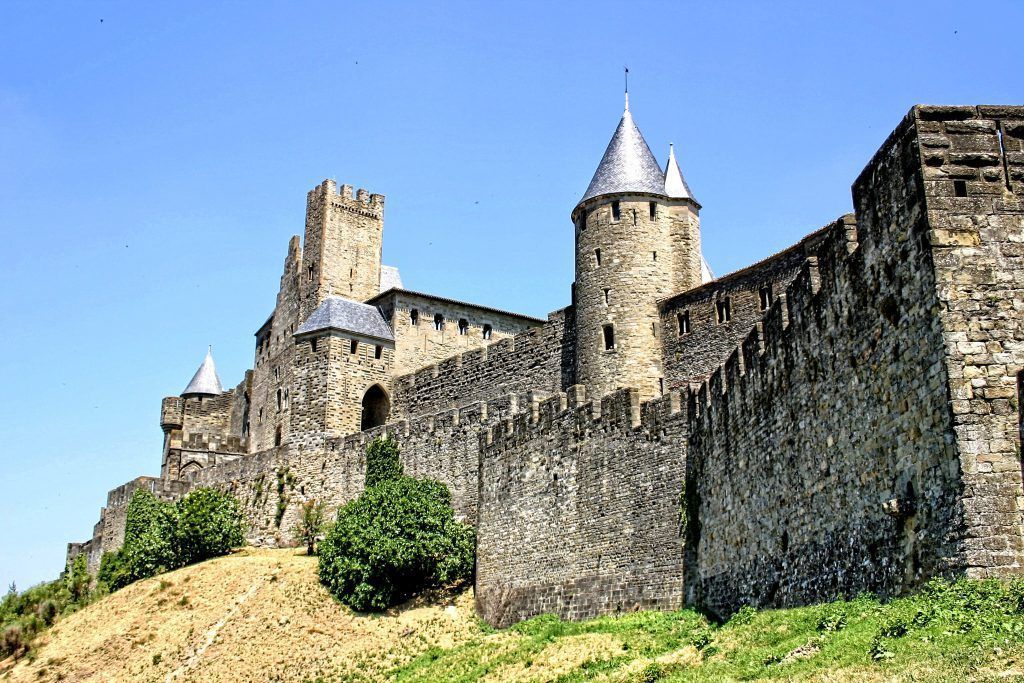 A large stone castle is sitting on top of a hill.