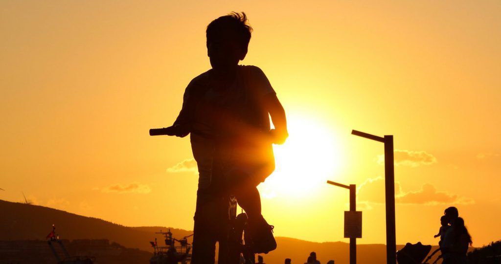 A person is riding a bike at sunset.