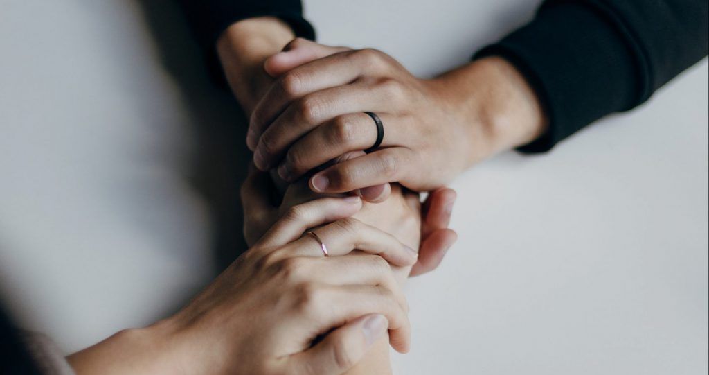 A man and a woman are holding hands on a table.