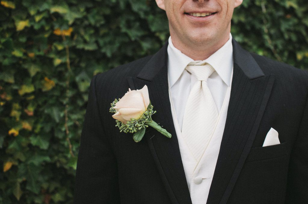 A man in a tuxedo with a flower in his pocket.