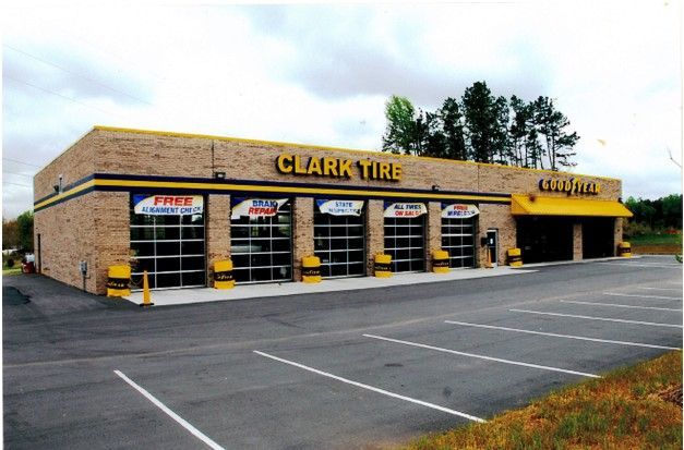 Clark Tire storefront in a parking lot, with yellow signage and empty spaces in front