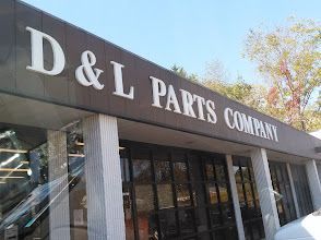 Storefront sign reading “D&L Parts Company” on a building exterior.