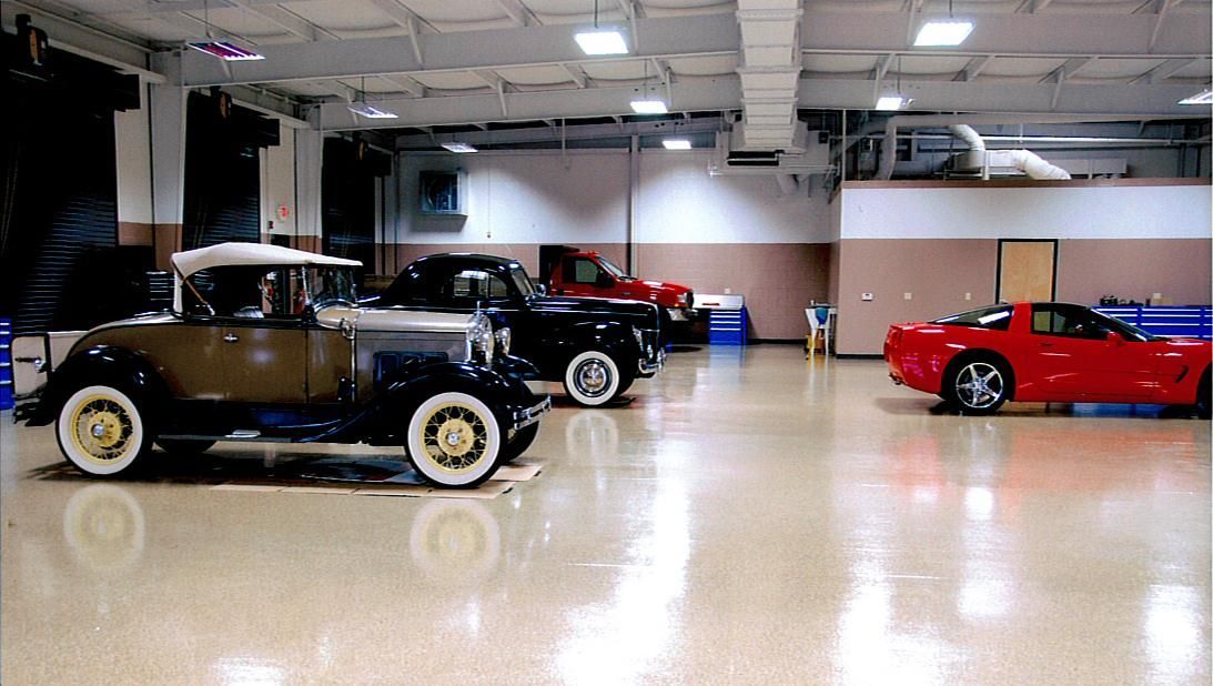 Classic cars parked inside a spacious indoor showroom or garage.