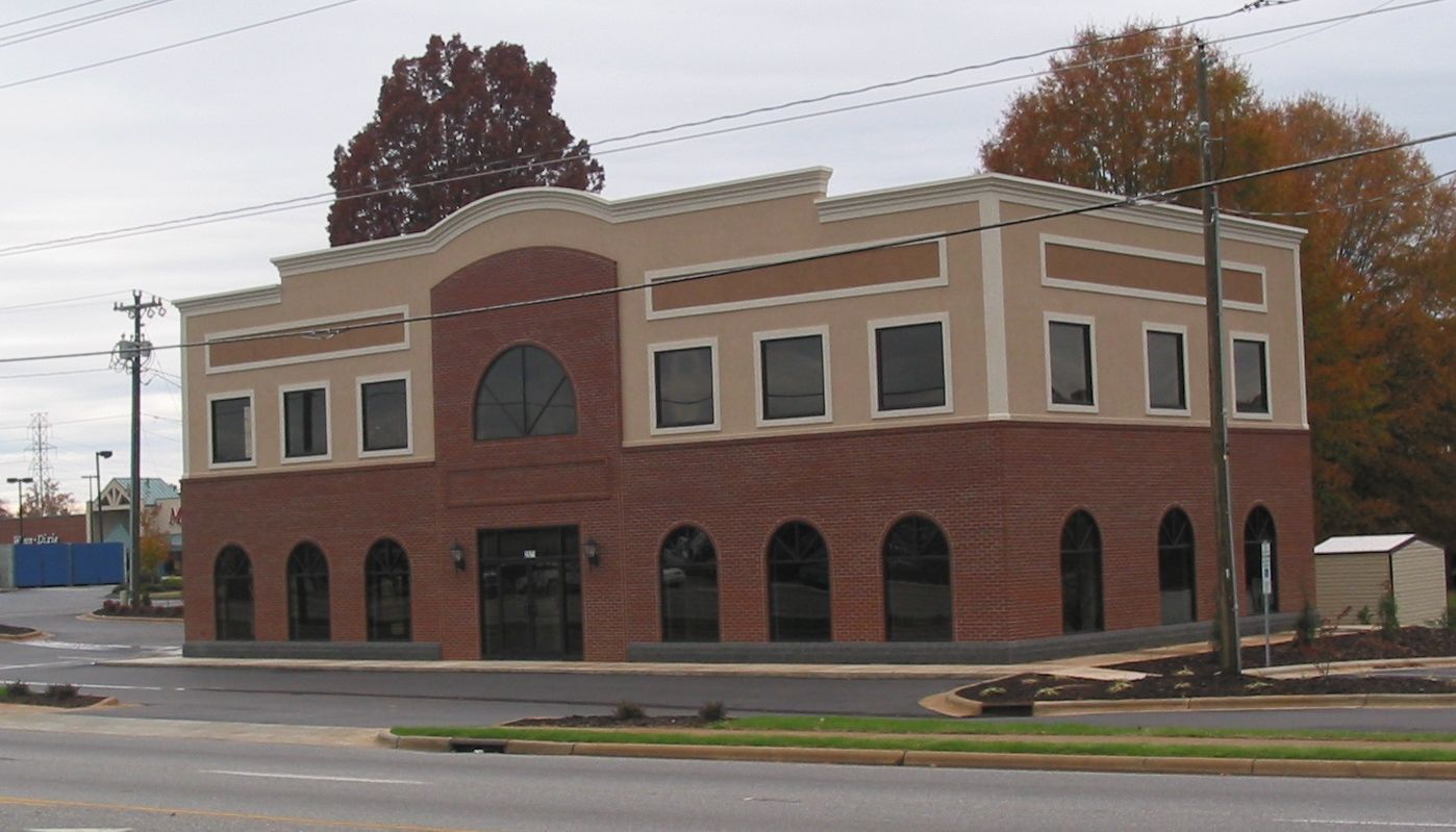 Two-story brick commercial building with arched windows on a street corner
