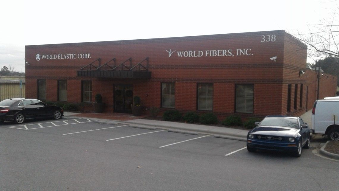 Brick office building with “WORLDWIDERS, INC” sign and parked cars in front