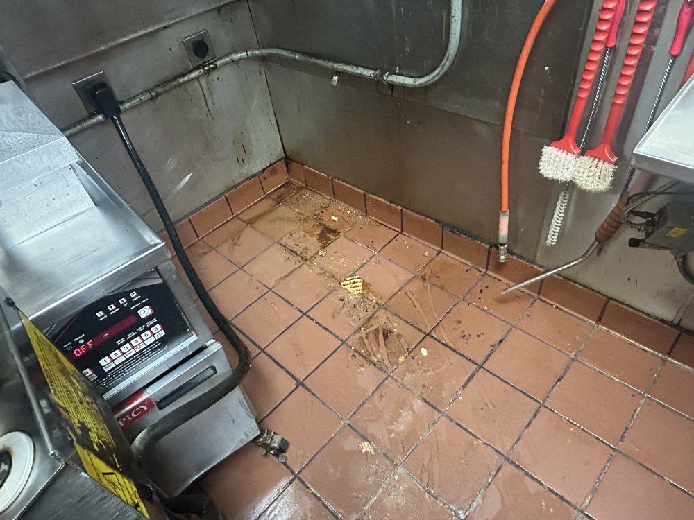 A dirty kitchen with a stainless steel appliance on the floor