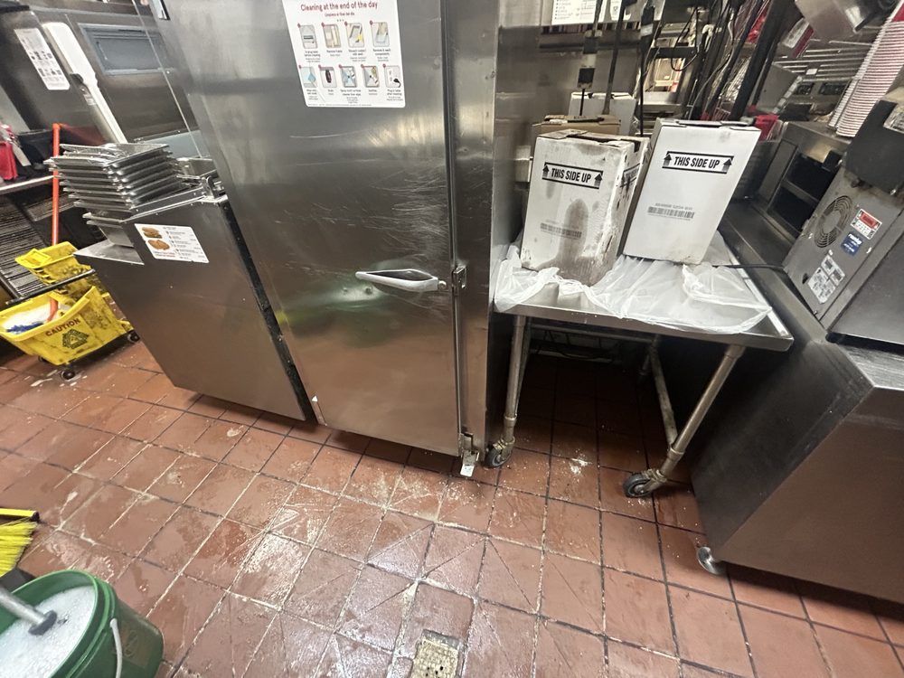 A kitchen with stainless steel appliances and a yellow mop.