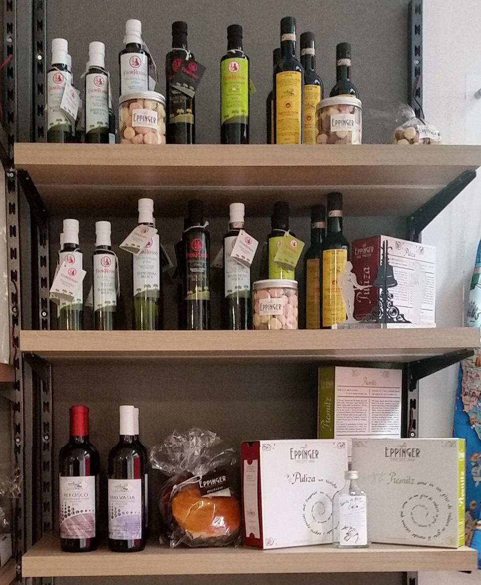 Scaffali che espongono varie bottiglie di olio e prodotti alimentari confezionati.
