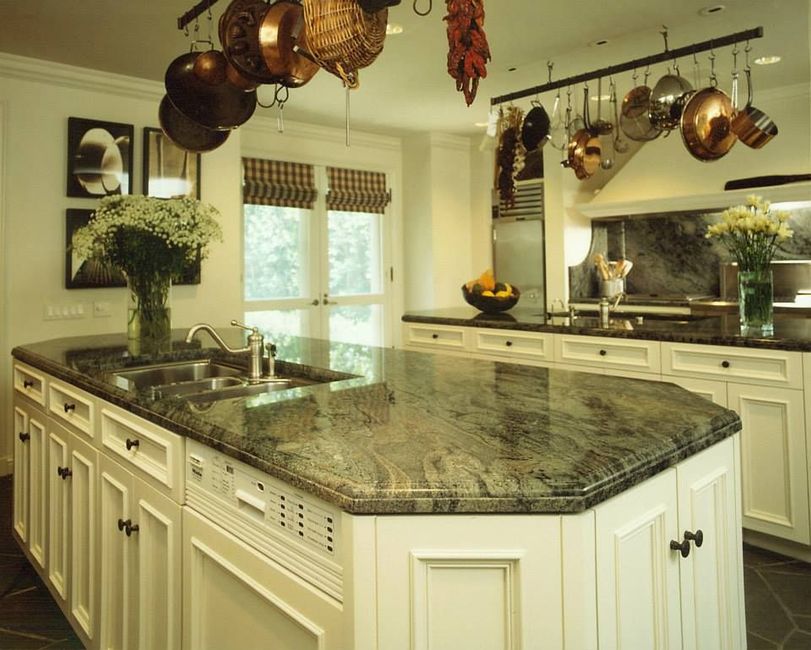 A kitchen with copper pots hanging from the ceiling
