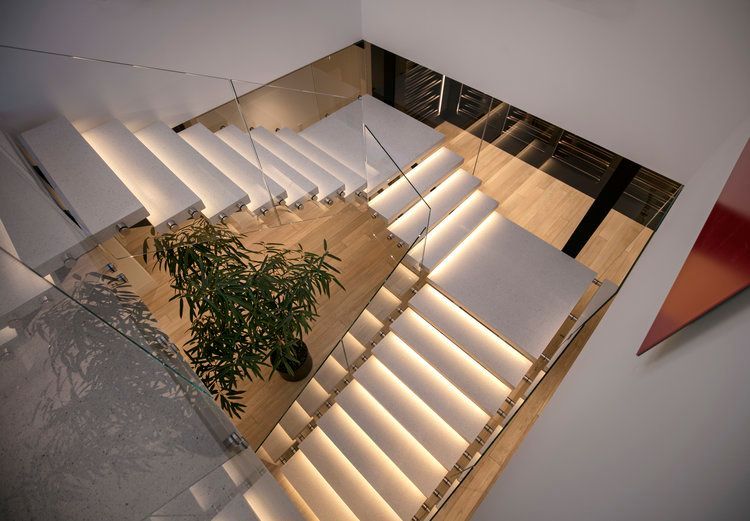 An aerial view of a staircase with white steps and a glass railing