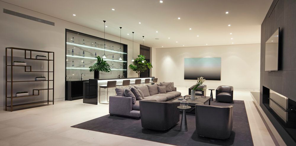 A living room with a couch , chairs , table and television.