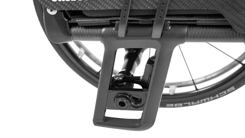 Black wheelchair front suspension with a black tire and the brand name 