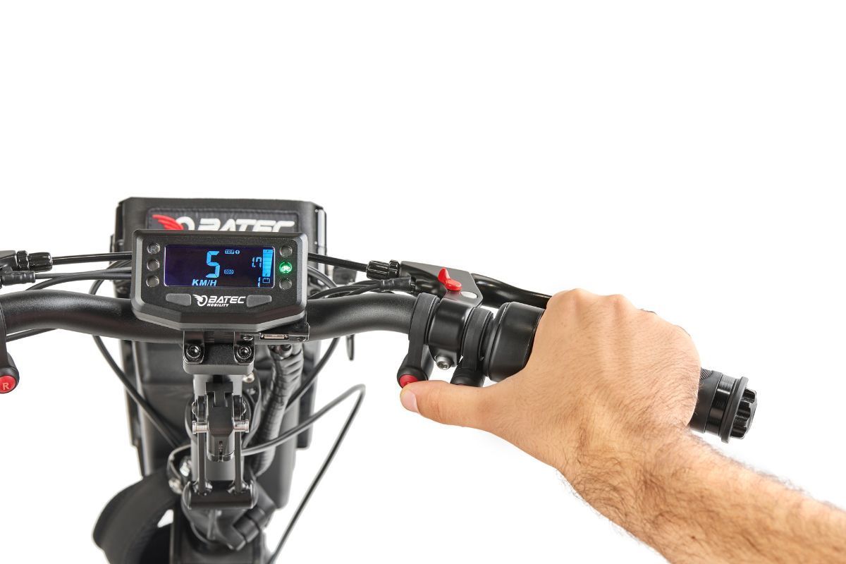 Hand operating scooter throttle, speedometer displays speed.