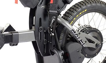 Black electric wheelchair attachment with rear wheel, gear, and hitch.