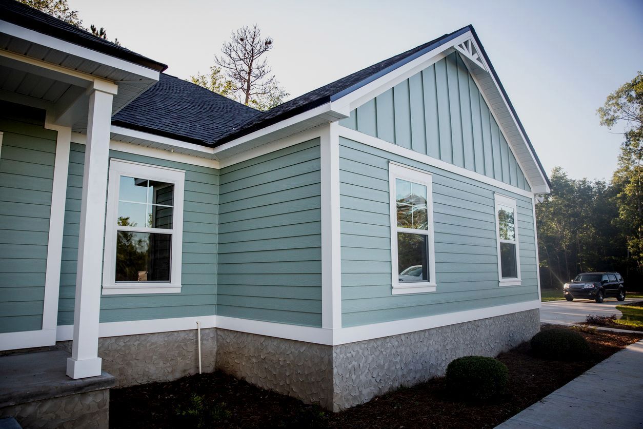 Light blue house exterior with white trim and a gray roof along a walkway