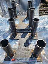 A bunch of metal pipes sitting on top of each other on a table.