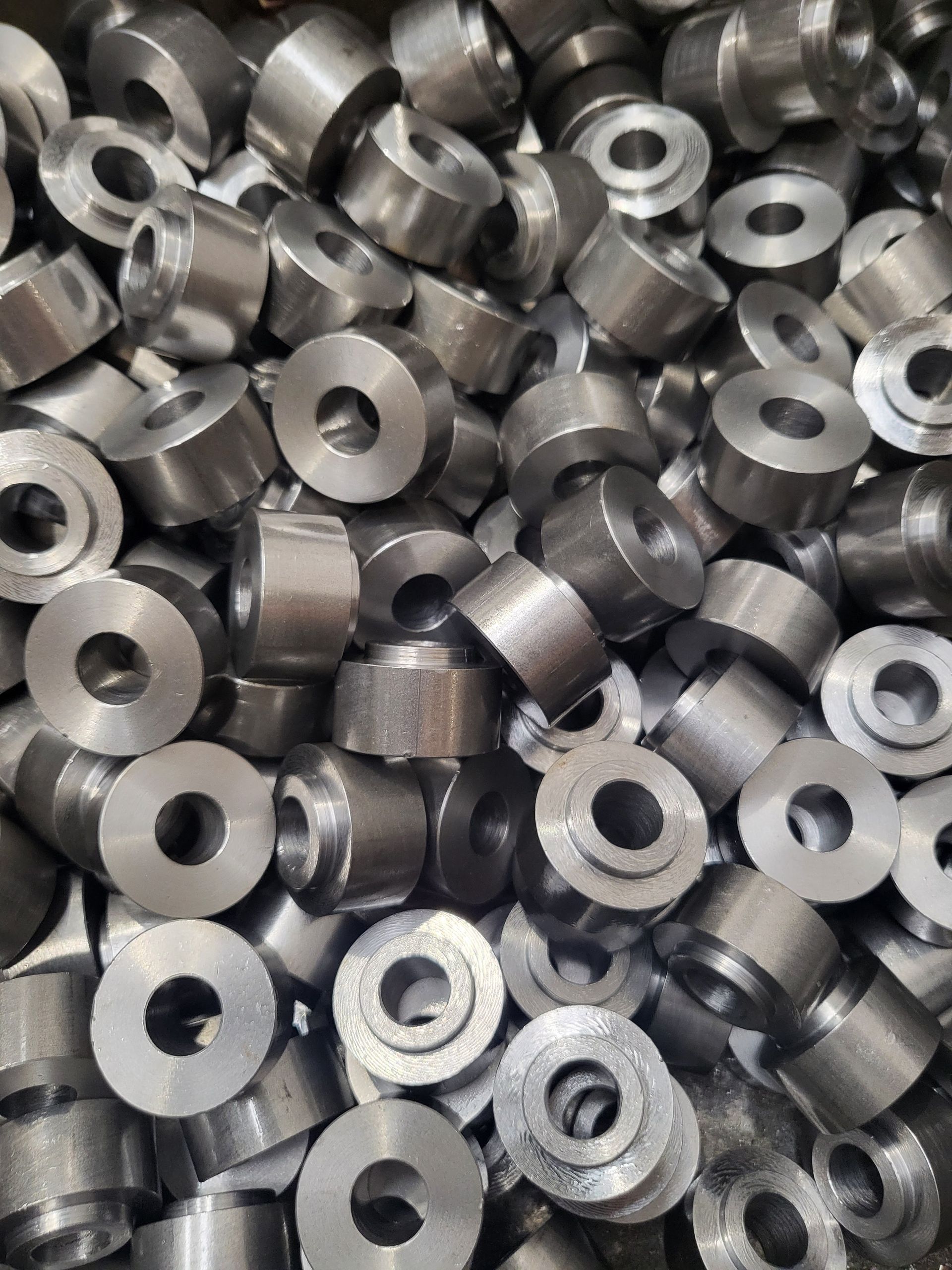 A pile of metal washers with holes in them