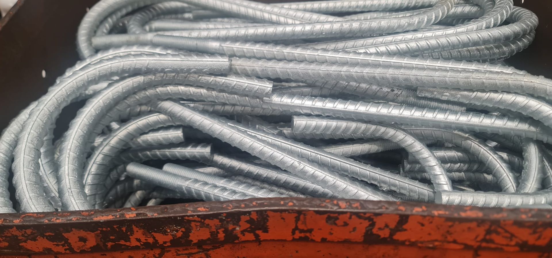 A bunch of metal bars are sitting in a rusty container.