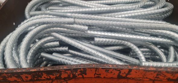 A bunch of metal bars are sitting in a rusty container.