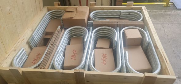 A wooden box filled with metal pipes and boxes