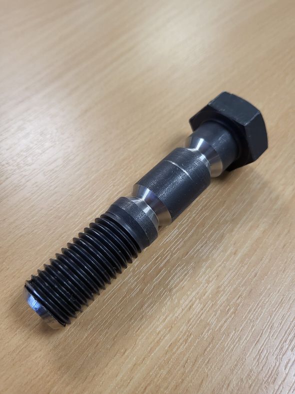 A close up of a bolt on a wooden table