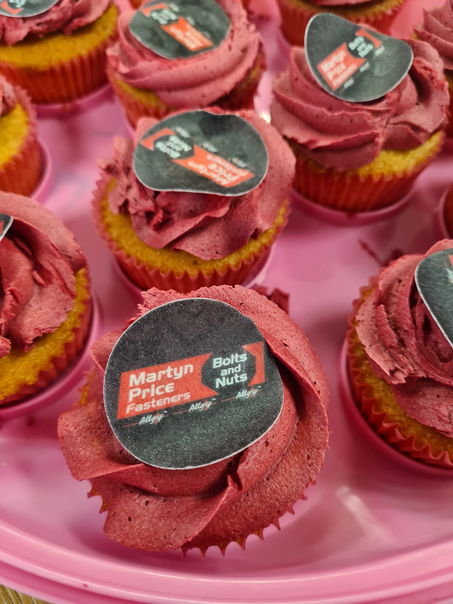 Cupcakes on a pink tray with one that says martin price on it
