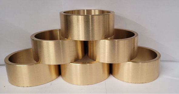 A stack of brass bearings sitting on top of each other on a table.