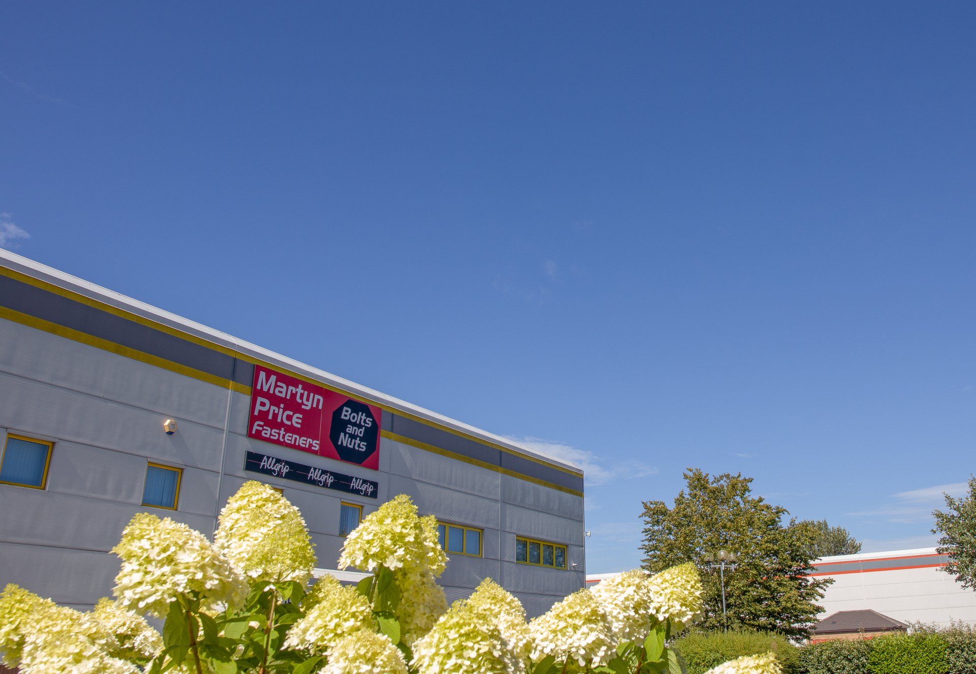 A building with flowers in front of it and a sign that says market price furniture