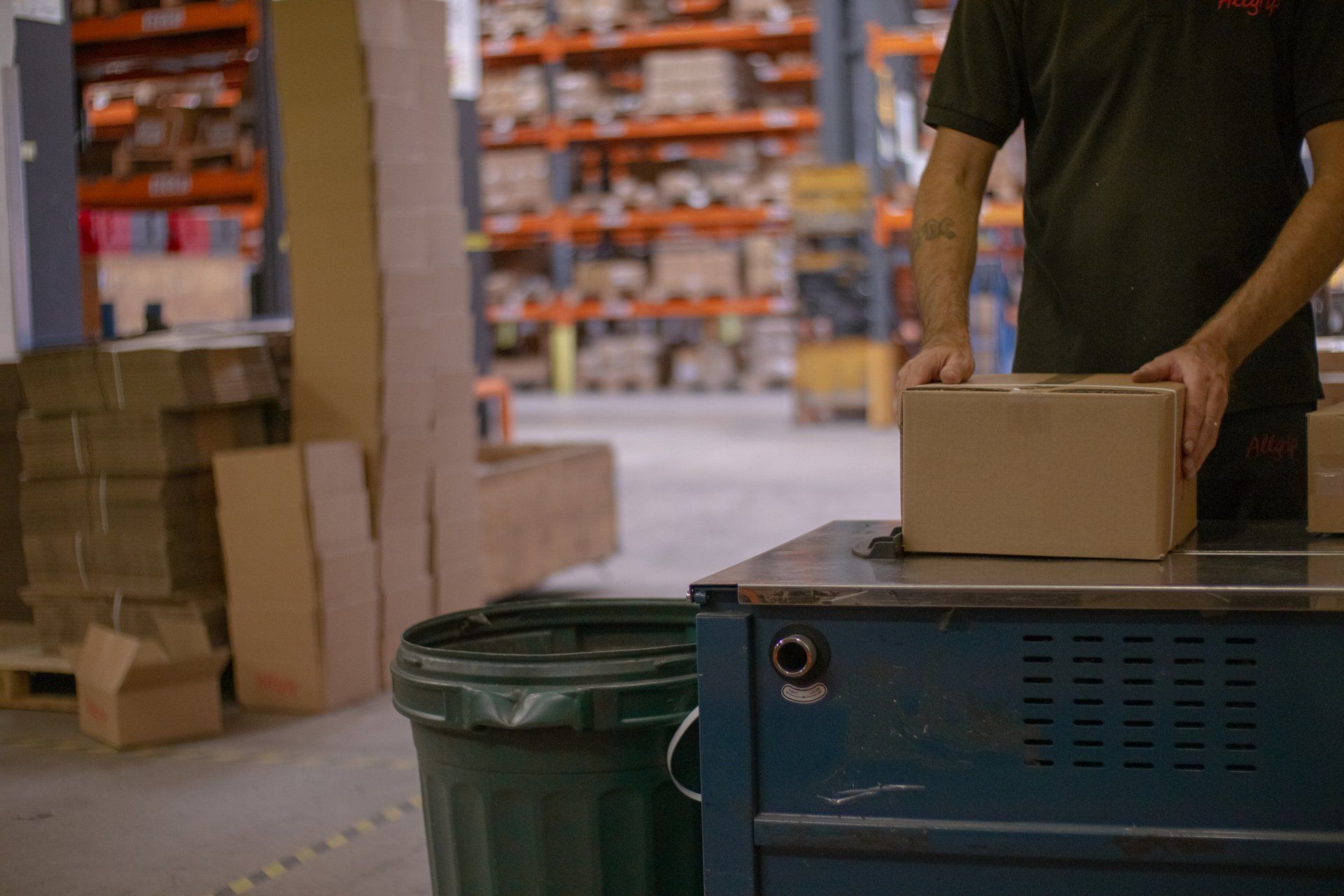 Martyn Price Worker placing a fastener box on a conveyor in a warehouse storeroom