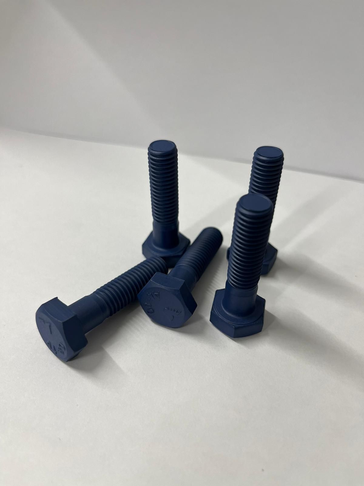 A group of blue bolts are sitting on a white surface.