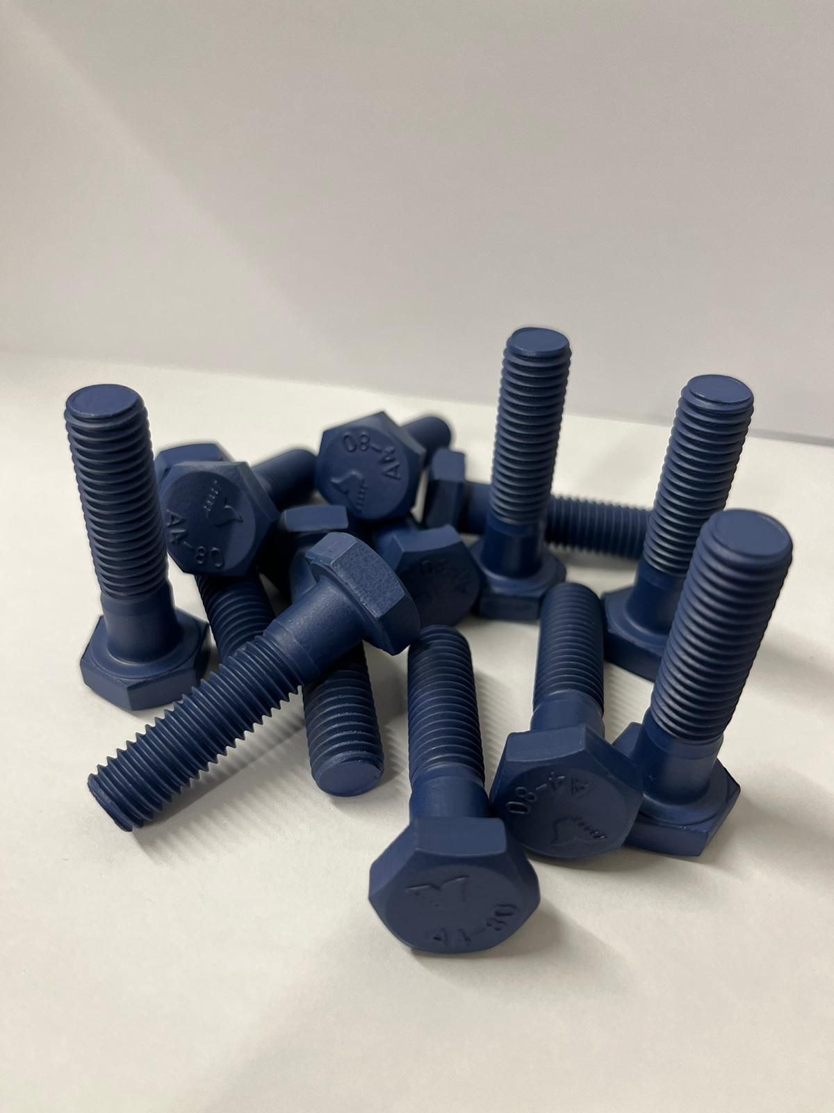 A bunch of blue bolts are sitting on a white surface.