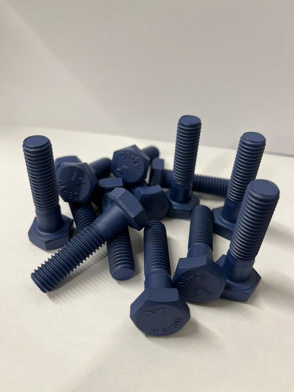 A bunch of blue bolts are sitting on a white surface.