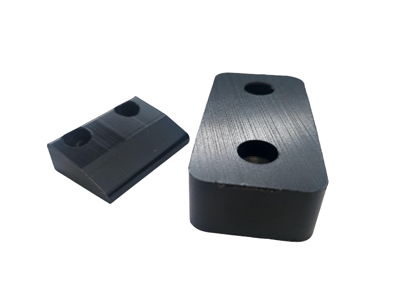 Two black blocks with holes in them on a white background