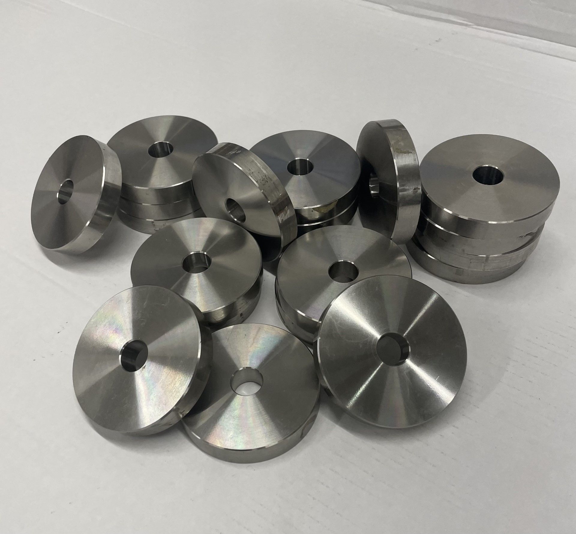 A pile of stainless steel washers with holes in them