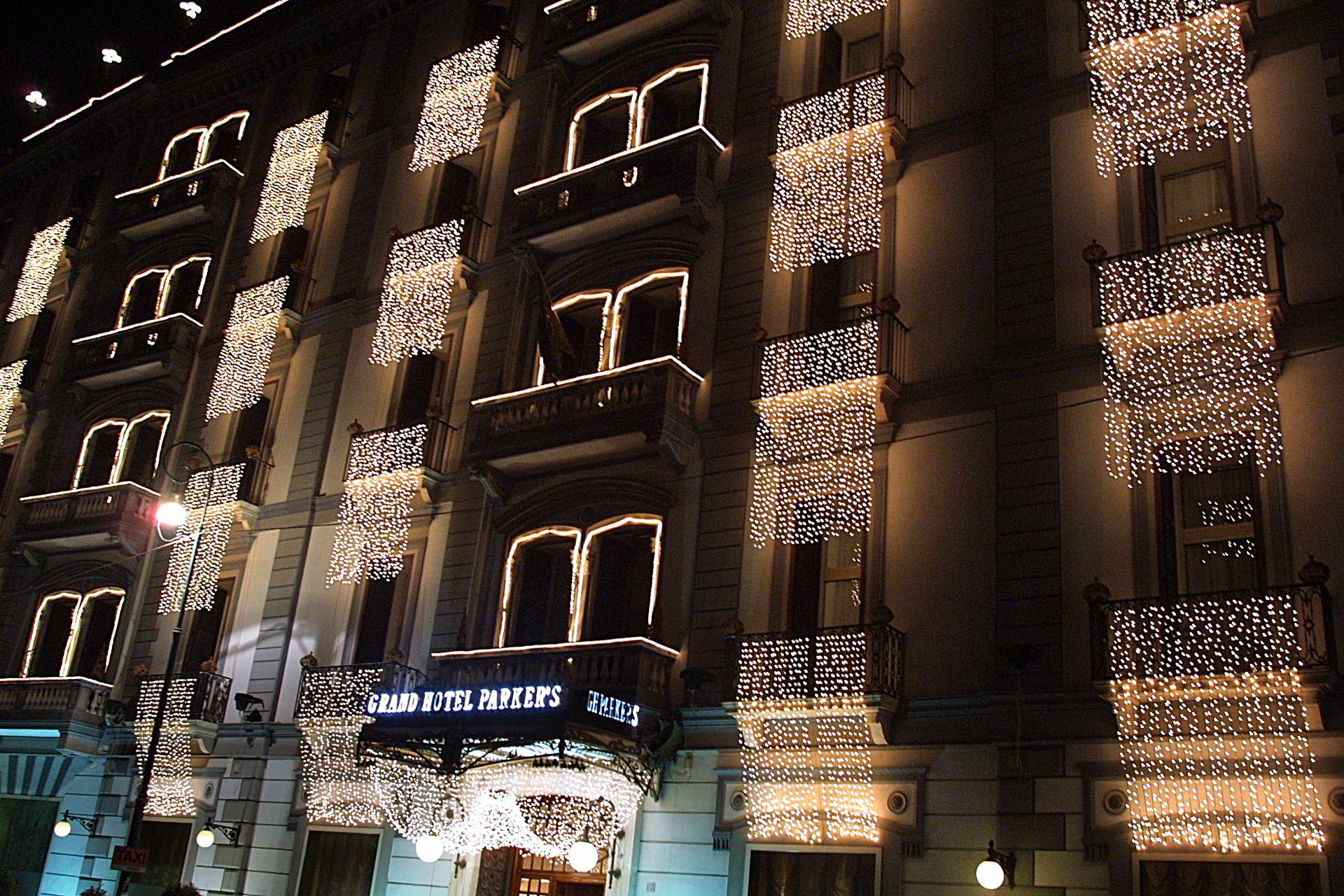 Edificio dell'hotel di notte, illuminato da calde luci decorative sulla facciata e sull'ingresso.