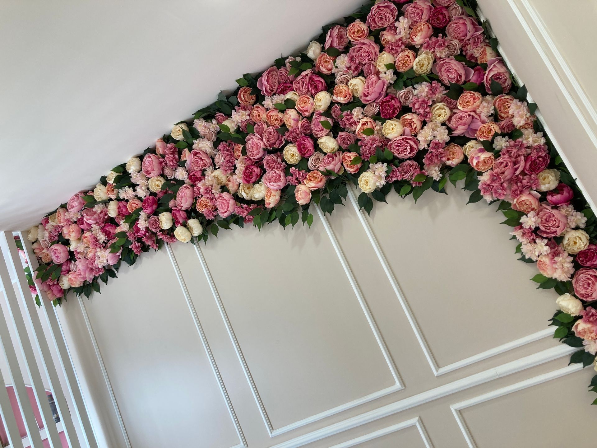 Composizione di fiori artificili incornicia parete