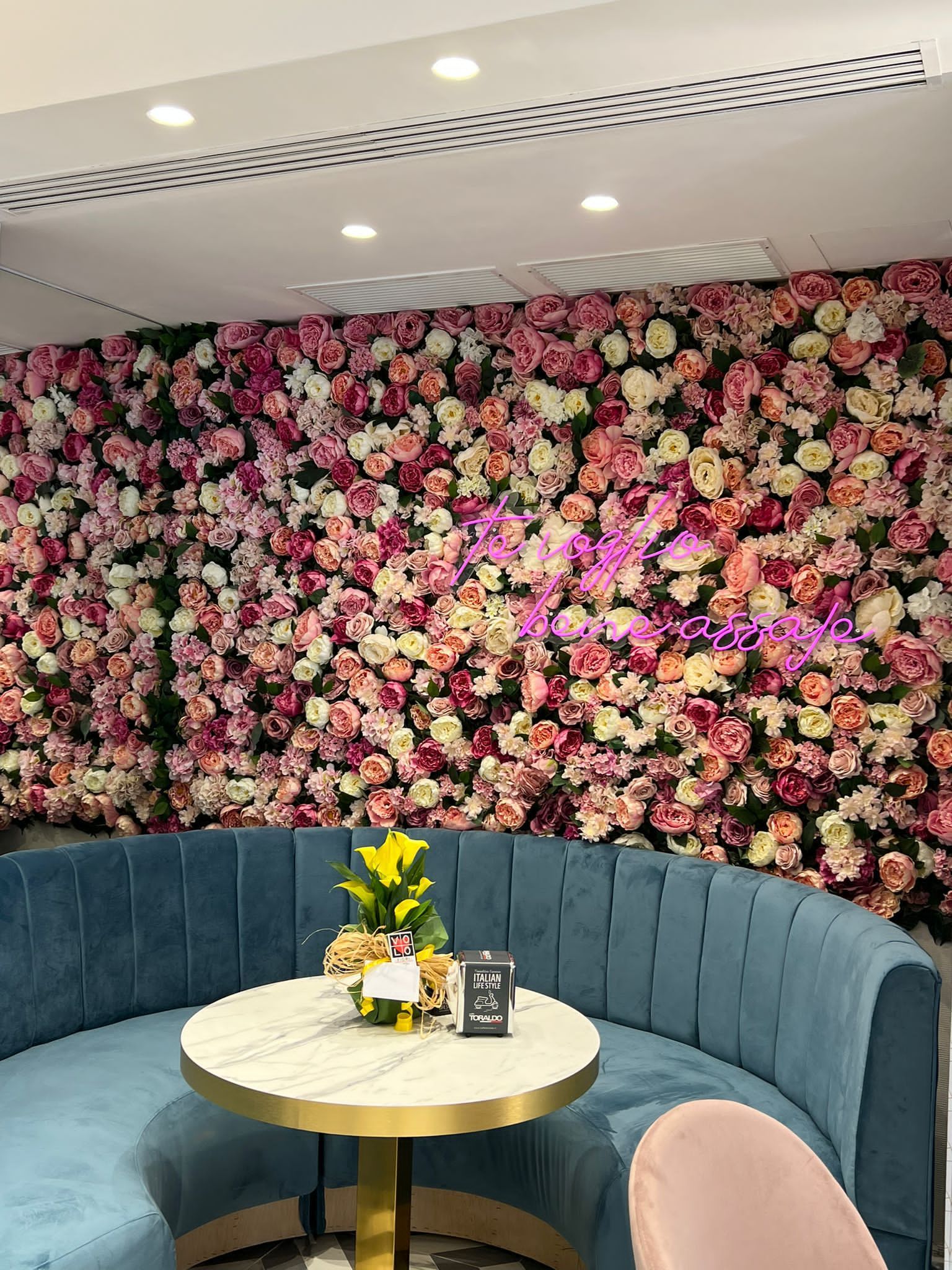 Parete curva interno ristorante composta da rose artificiali
