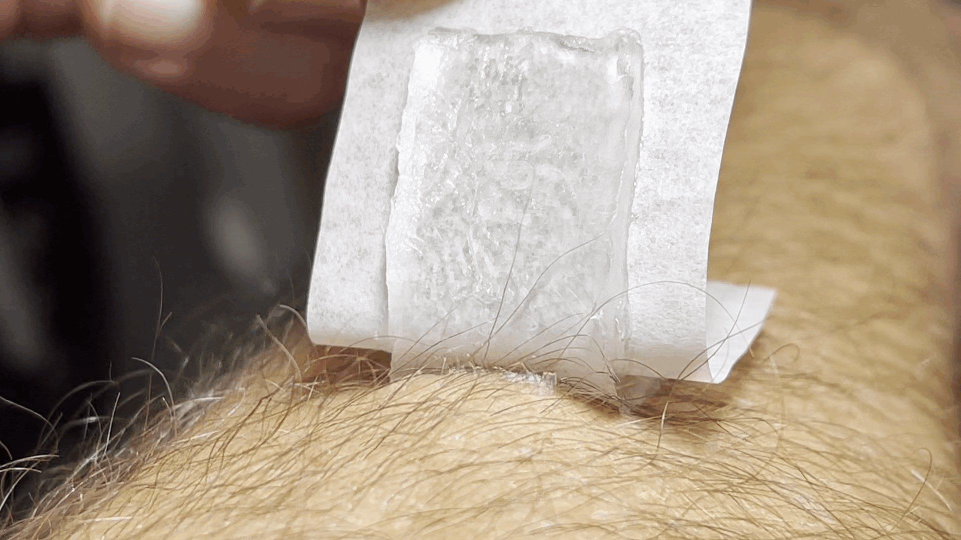 A person is holding a piece of paper on their arm.