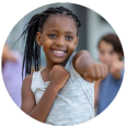 A young girl is pointing at the camera and smiling.