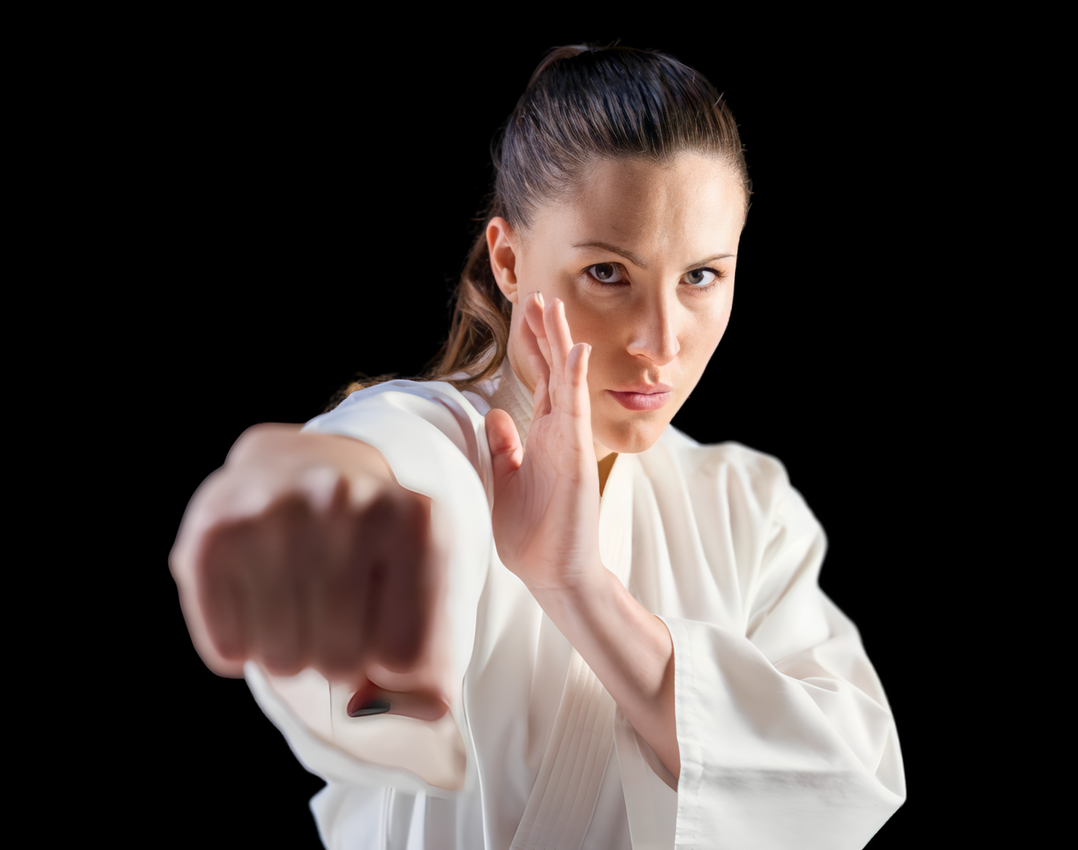 A man is practicing karate in front of a wooden wall.
