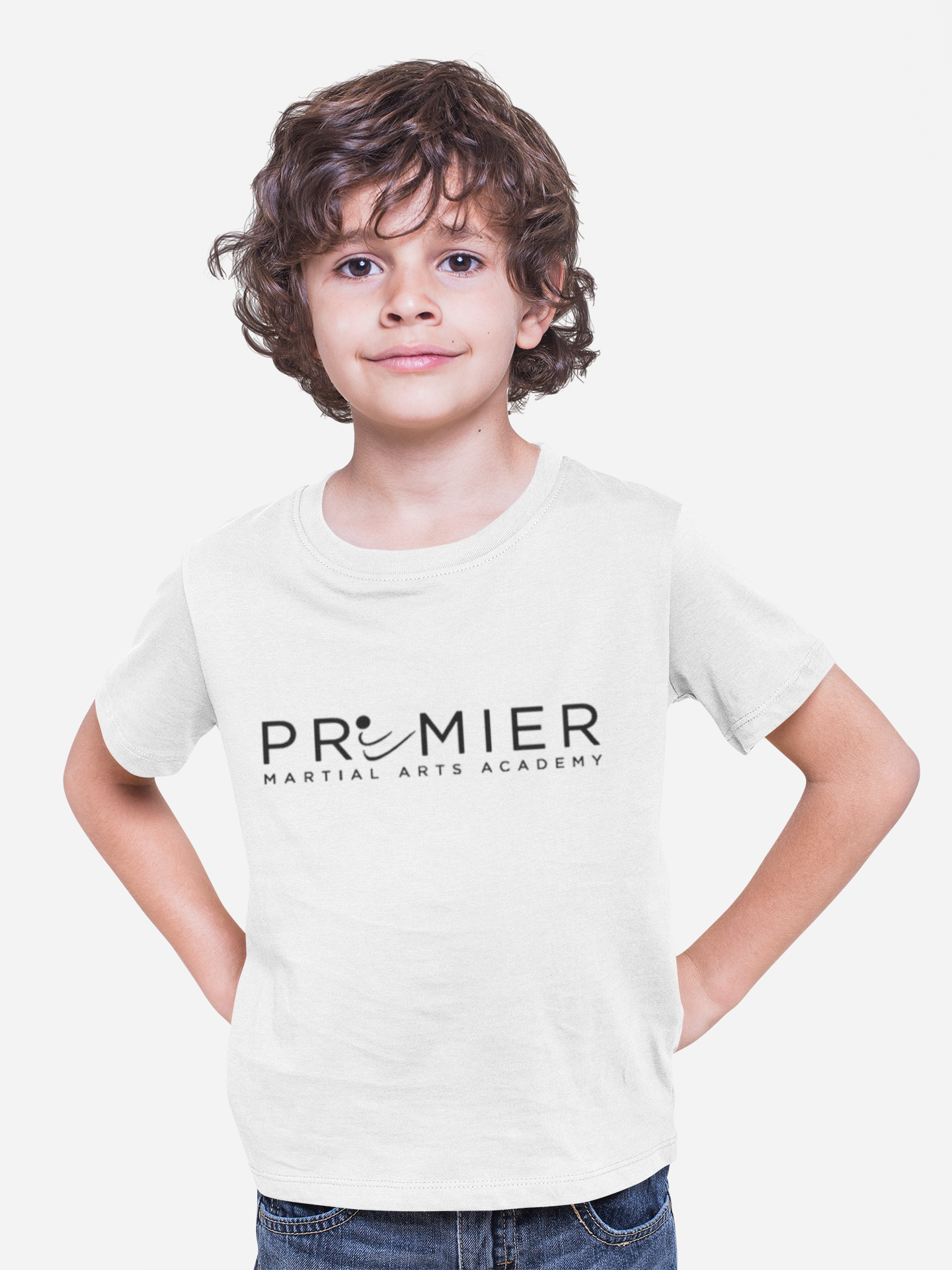 A young boy wearing a white t-shirt that says premier martial arts academy