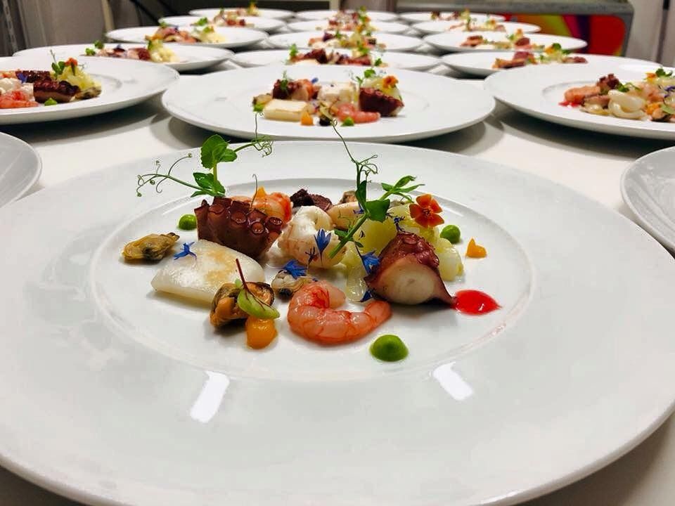 Un piatto di cibo con gamberi e verdure su un tavolo.