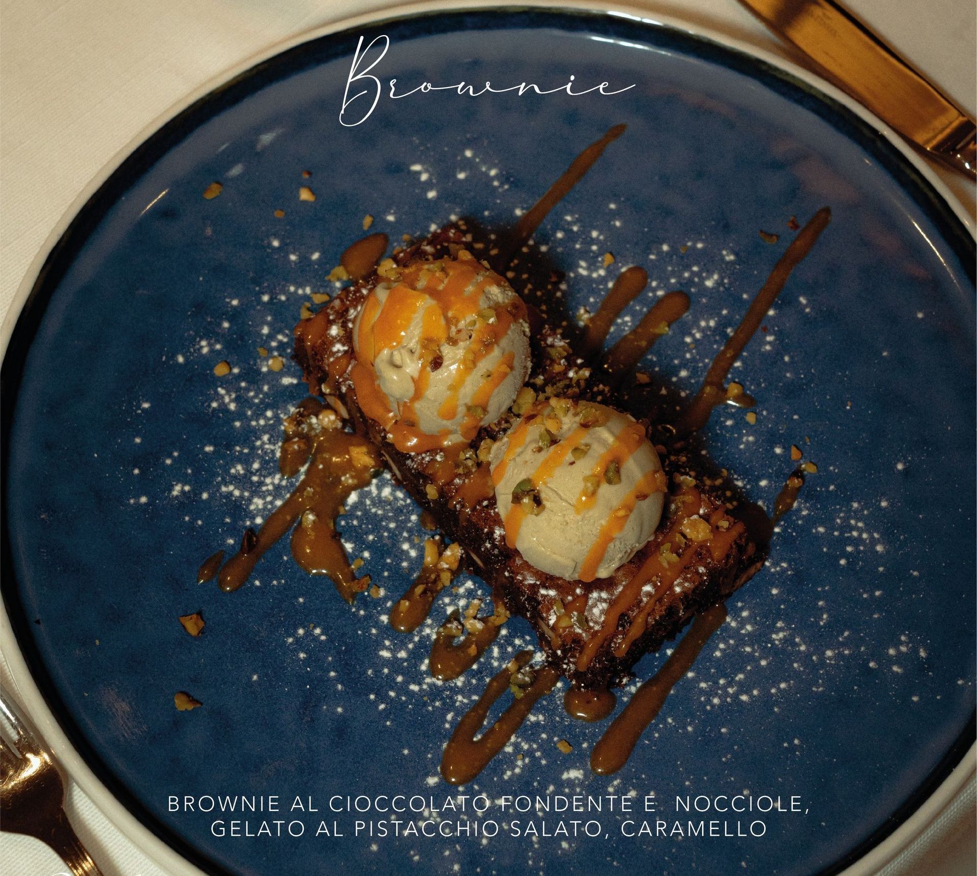 Un piatto blu con un brownie e un gelato sopra