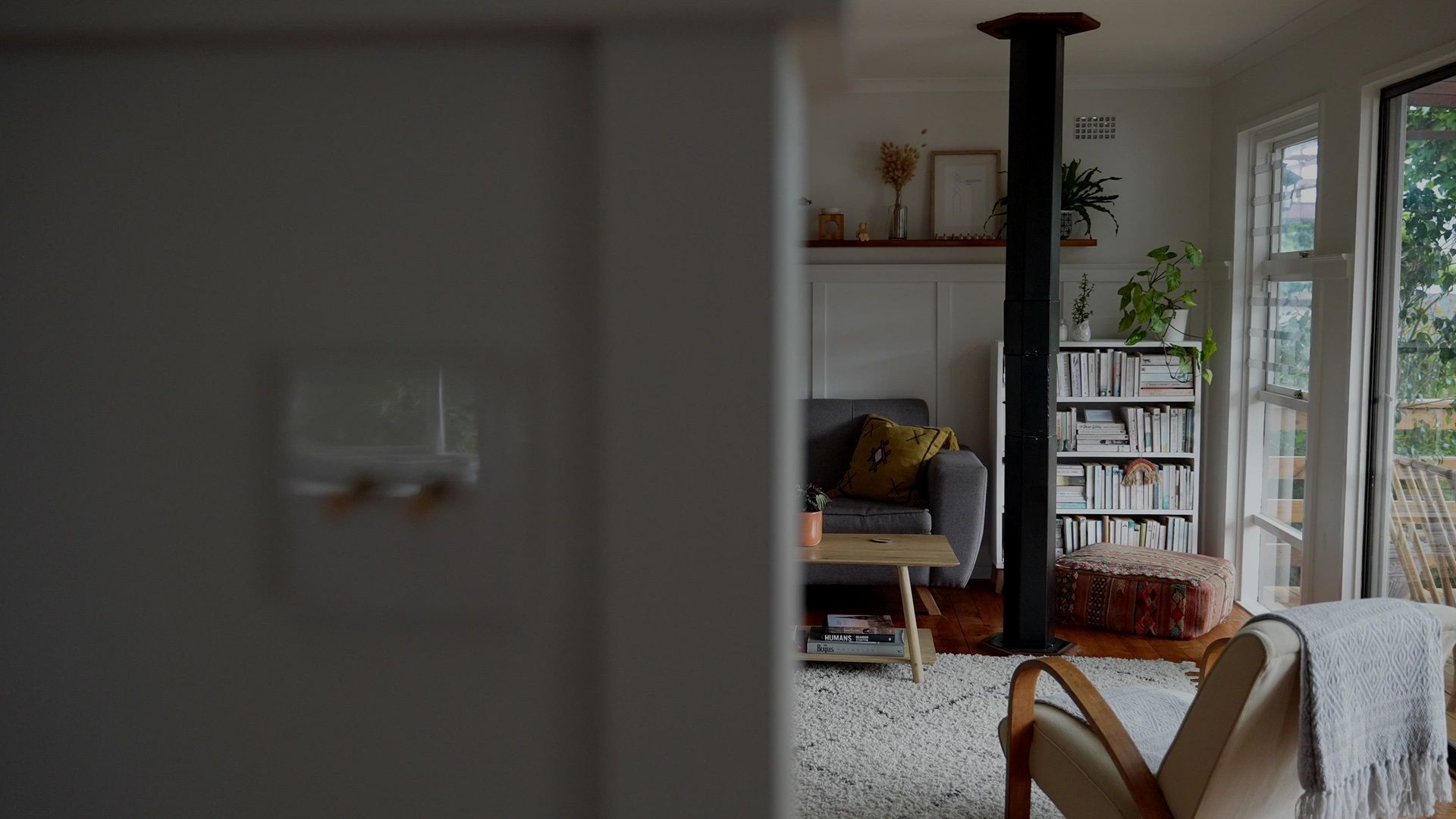 A living room with a fireplace , couch , chair and bookshelf.