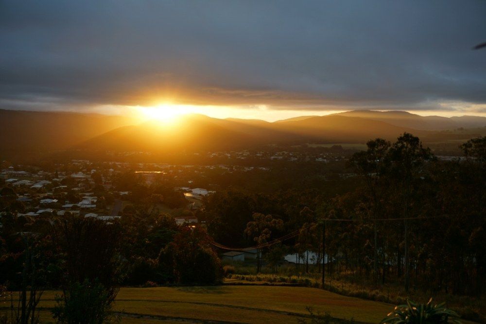 Sunrise Over a Town and Mountains — All Grind & Coat in Tablelands, QLD