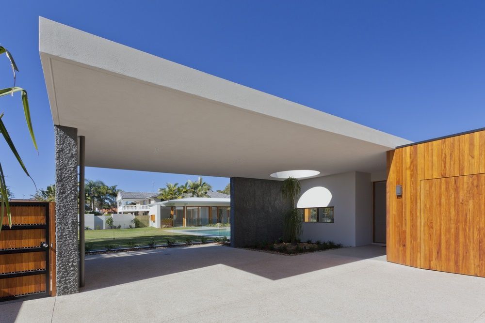 Modern Home With a White Carport, Wood Door, and a View of a Pool and Lawn — All Grind & Coat in Port Douglas, QLD