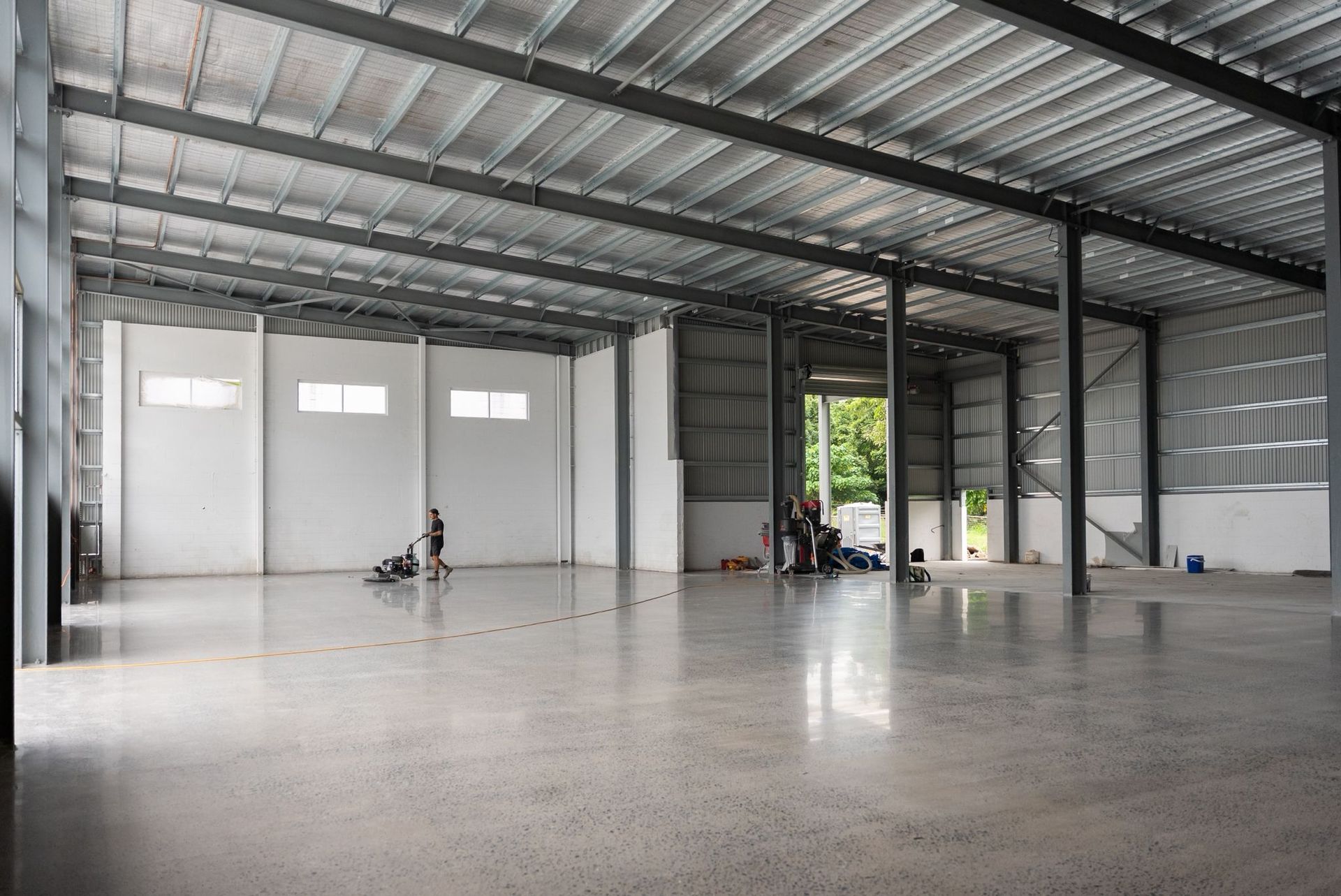 Empty Industrial Warehouse Interior With Metal Roof, Concrete Floor — All Grind & Coat in Cairns, QLD