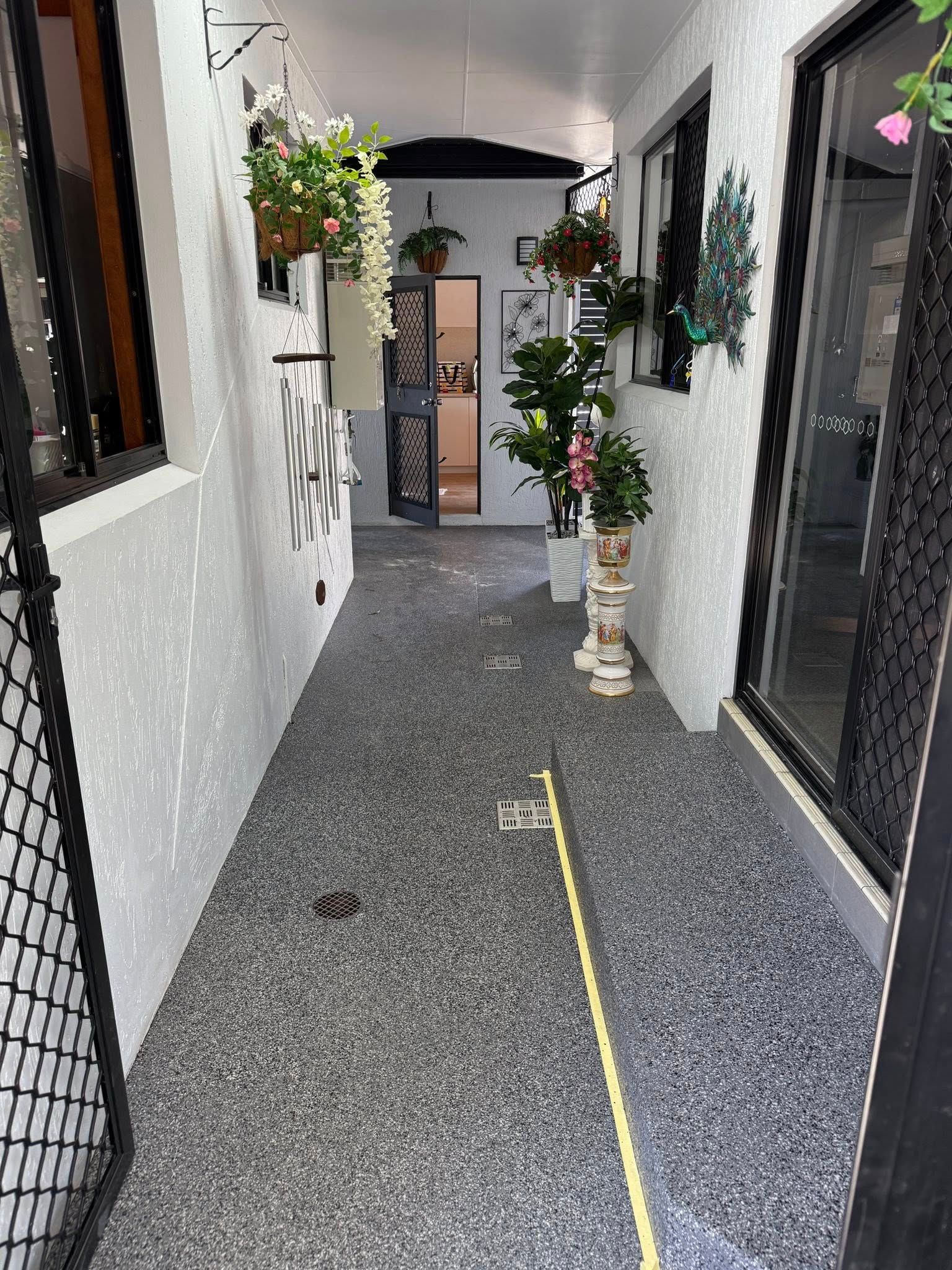 A Gloved Hand Pouring Gray Sealant Into A Crack In A Concrete Surface — All Grind & Coat in Cairns, QLD