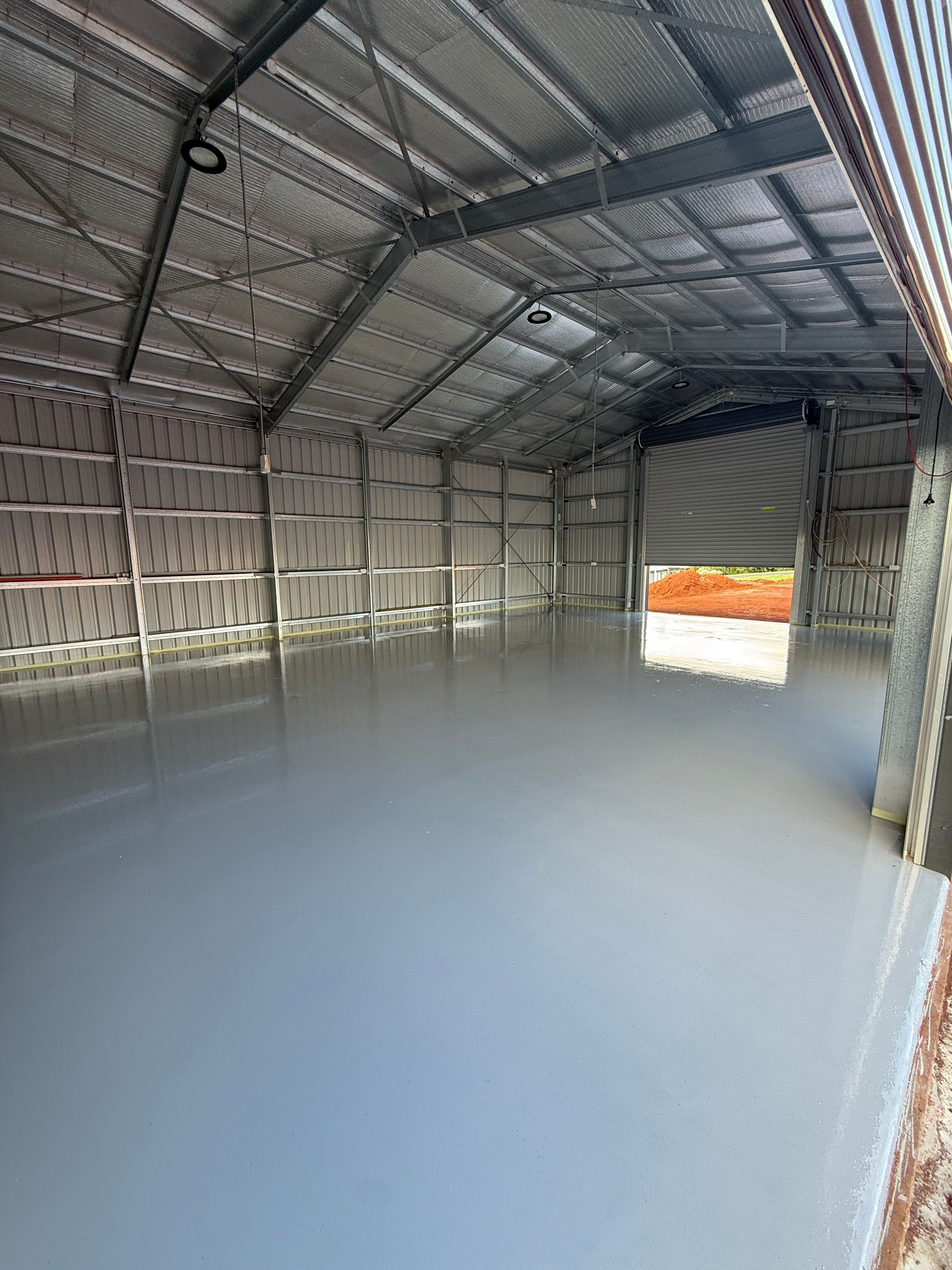 Interior of a Metal Warehouse With a Smooth Grey Concrete Floor — All Grind & Coat in Cairns, QLD