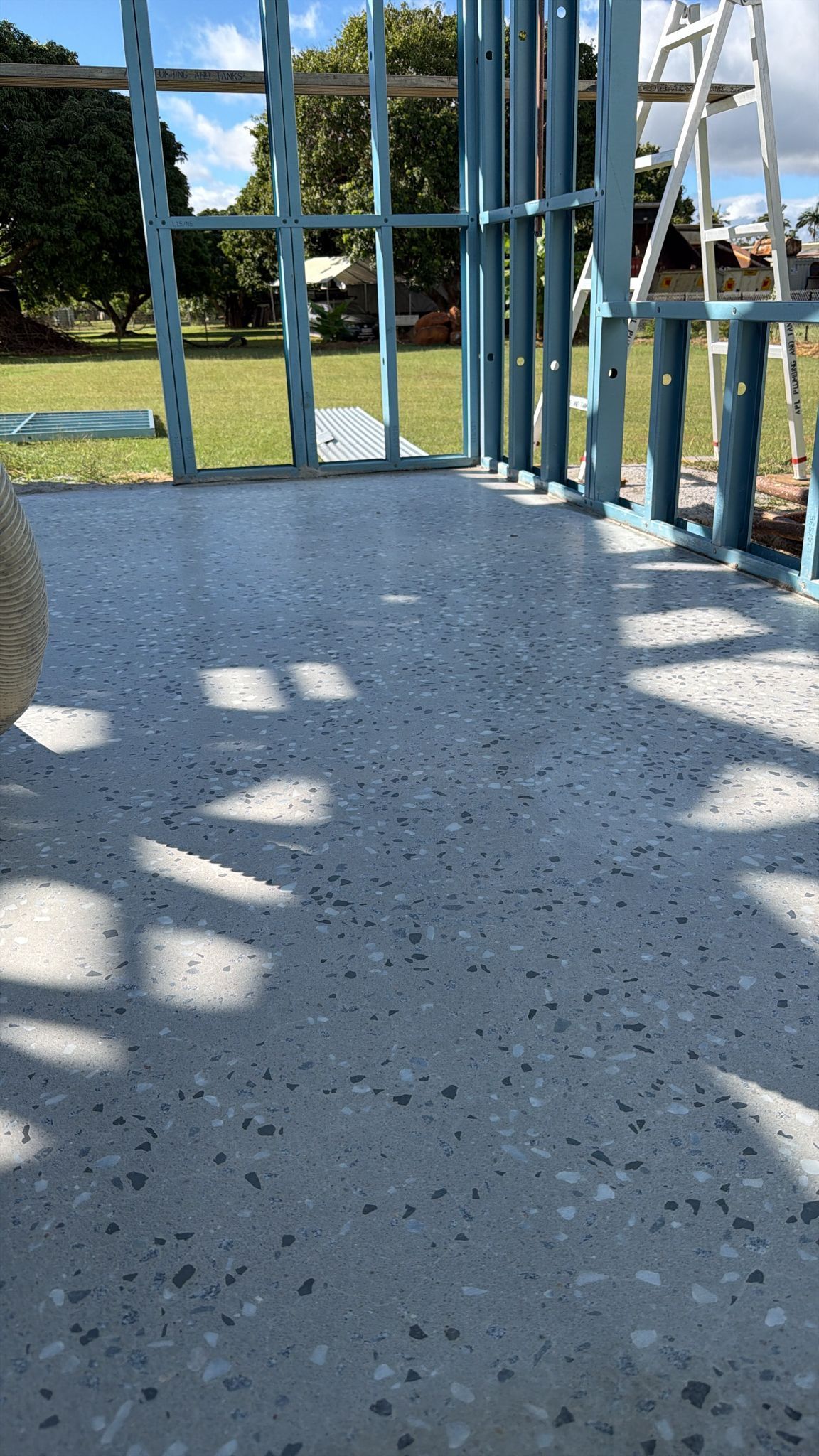 Blue-painted Porch With Speckled Concrete Floor and Sunlight Shadows — All Grind & Coat in Cairns, QLD